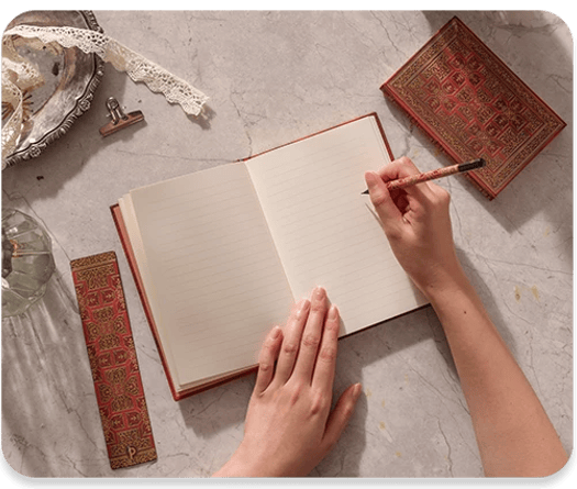 Person writing on new folger shakespear opened journal.