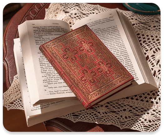 Folger shakespear hard cover journal laid on top of an open book.