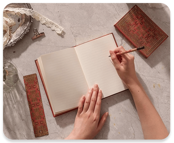 Person writing on new folger shakespear opened journal.